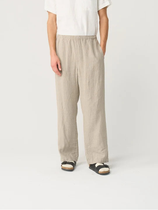 Man wearing a white t-shirt and beige pants on a white background